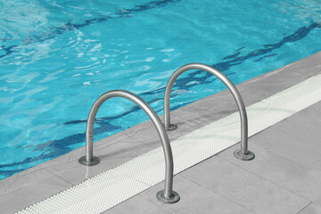 Obraz na płótnie Canvas Ladder with handrails in outdoor swimming pool