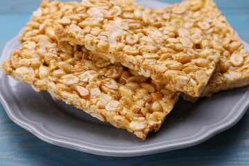 Delicious peanut bars (kozinaki) on light blue wooden table, closeup