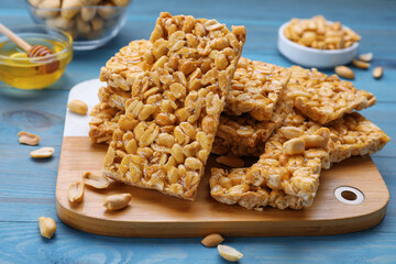 Delicious peanut bars (kozinaki) and ingredients on light blue wooden table