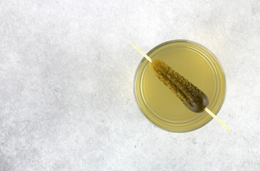 Cucumber pickle or pickle juice in a glass on a gray background. Top view. Copy Space. Trend drink. The concept of sports nutrition. 