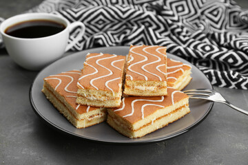 Tasty sponge cakes and hot drink on grey table