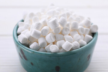 Fototapeta na wymiar Bowl with delicious marshmallows on white table, closeup
