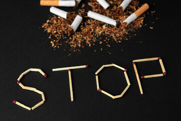Word Stop made of matches and broken cigarettes on black background, above view. Quitting smoking concept