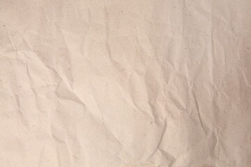 Sheet of crumpled light brown paper as background, top view