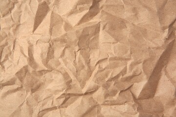 Obraz premium Sheet of crumpled kraft paper as background, top view