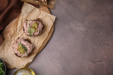 Delicious liverwurst sandwiches with pickled cucumber and mustard on grey table, top view. Space for text