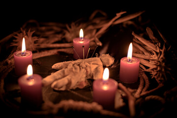 Occultist dripping hot wax on voodoo doll, magic rituals, black spell, horror.