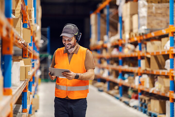 A post office worker is using tablet and headset for tracking shipment while smiling at the tablet. - Powered by Adobe
