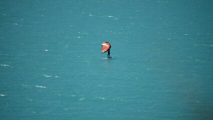 Hand-held wing used to do foil surfing in beautiful turquoise alpine lake - Powered by Adobe