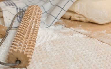 Bake flatbread with a rolling pin on a floured baking table in a country kitchen