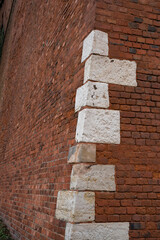 Antique corner masonry of red brick with the addition of large white stones