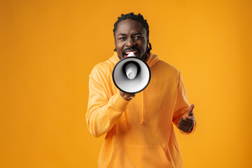 Young african man against yellow background with megaphone