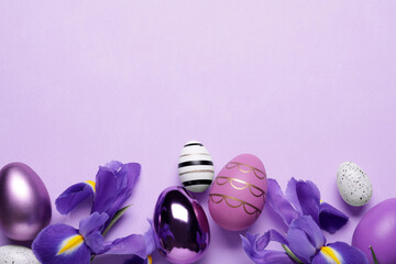 Flat lay composition with iris flowers and beautifully painted eggs on violet background, space for text. Easter celebration