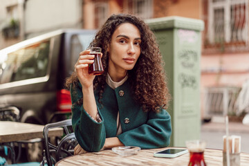 Woman tourist drinking traditional Turkish tea in outdoor cafe - obrazy, fototapety, plakaty