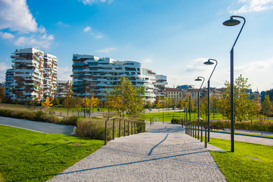 Hadid Residences by Zaha Hadid Architects in CityLife, Milan, Italy &mdash; luxury residential buildings with curved white balconies overlooking a green urban park with people walking.