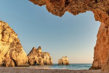 Wall murals Marinha Beach, The Algarve, Portugal Algarve, Portugal - View of the beach and Alvor from a cave - Cliffs illuminated by the sunset - Summer vacation concept