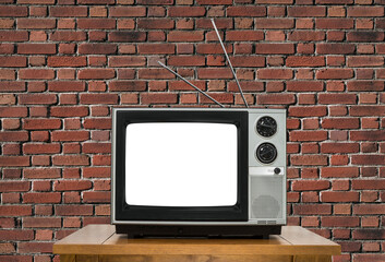 Vintage television with antennas with brick wall background and cut out screen.