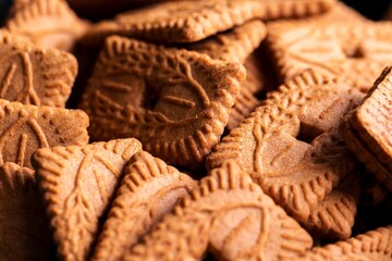 A pile of multiple brown cookies called speculoos or speculaas in Belgium or the Netherlangs. The...