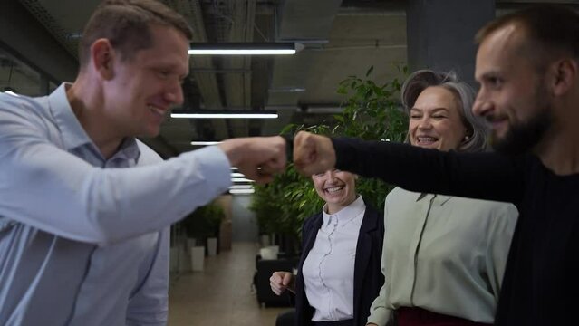Caucasian man bumping his fists with colleagues as a sign of success. Slow motion. 