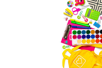 Back to school, education concept. Yellow backpack with school supplies - notebook, pens, ruler, calculator, scissors isolated on white background