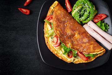 Keto breakfast. Omelette tomato, olives and avocado, ham. Ketogenic diet. Low carb high fat breakfast. Healthy food concept.  Top view