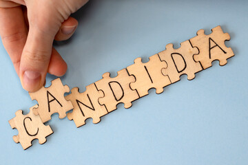 Candida is a word of wooden puzzles with letters, the concept of the parasitic fungus candida, blue...