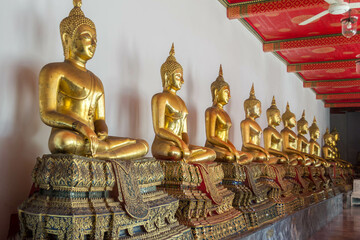 Seated Golden Buddhas along the wall at Wat Phra Chetuphon, Bangkok, Thailand.