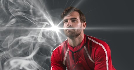 Caucasian male athlete against smoke effect and light spot on grey background