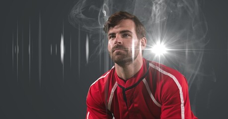 Caucasian male athlete against smoke effect and light spot on grey background