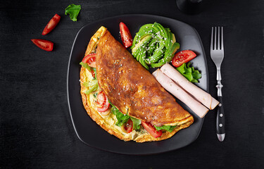 Keto breakfast. Omelette tomato, olives and avocado, ham. Ketogenic diet. Low carb high fat breakfast. Healthy food concept.  Top view