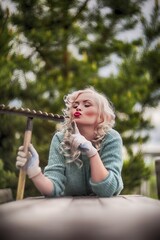beautiful girl summer resident in the garden and rake with gloves