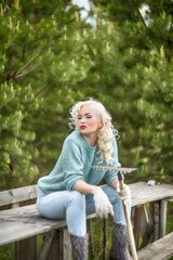 beautiful girl summer resident in the garden and rake with gloves