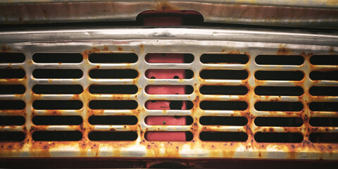 Rusty metal retro automobile front grill close up view. Part of abandoned old car with rust on...