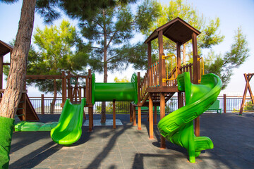 Green children's slide and tube maze outdoors.