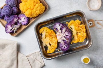 Vegetable colorful cauliflower steaks. Сooking vegan or vegetarian meal. Healthy plant based food. Gray background, top view.