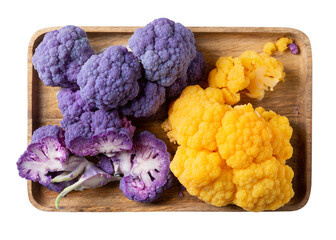 Boiled colorful cauliflower on wooden tray isolated on white. Purple and yellow hybrids of cauliflower on gray background. Healthy plant based food. Top view.