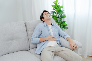Obraz premium stomach ache. Asian men have abdominal pain, indigestion, gastritis, menstrual cramps, flatulence, diarrhea, distention, colon cancer, belly inflammation problem, suffer food poisoning, abdomen