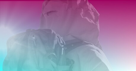Composition of rear view of skier with copy space and blue to pink tint