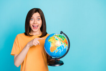 Fototapeta premium Photo of astonished lady wear stylish clothes hand direct map choose country start trip empty space isolated on blue color background