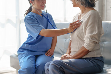 Young asian caretaker with 60s asia elderly woman consulting and encourage, take a history and recommend the right treatment, Use a stethoscope to listen to your heartbeat and check for abnormalities.