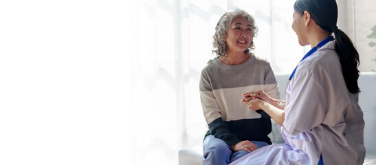 Young asian caretaker with 60s asia elderly woman consulting and encourage, take a history and recommend the right treatment, holding hands and encouraging