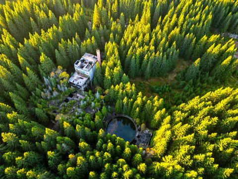 Ruins of former tin mine near Rolava village in the forests of Ore Mountains, Czech Republic. Aerial view from drone.
