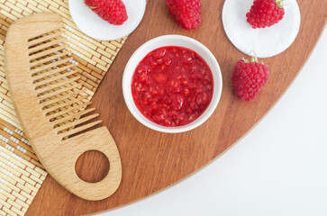 Raspberry mask (scrub) in a small white bowl. Homemade face or eye mask, natural beauty treatment and spa recipe. Copy space.