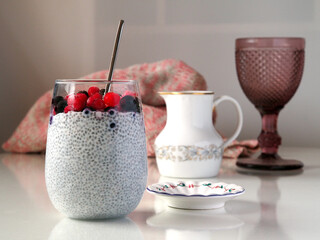 Chia Seed Pudding with Berries in the glass on a light background.