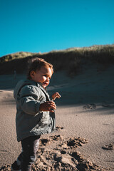 Kleinkind am Strand erkundet mit Freude die Natur
