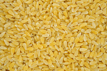 Pasta orzo background top view.