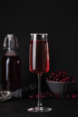 Cranberry mimosa cocktail on dark background. Cocktail garnished with sugar and fresh cranberries.