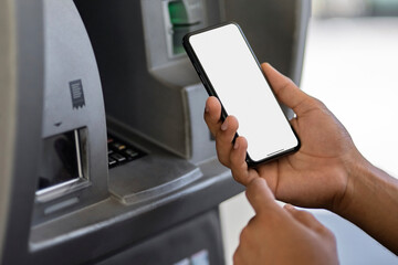 Man hand using mobile phone at gas pump station to pay for gasoline