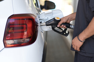 Cropped view of the man hand refuelling his luxury car at the gas station