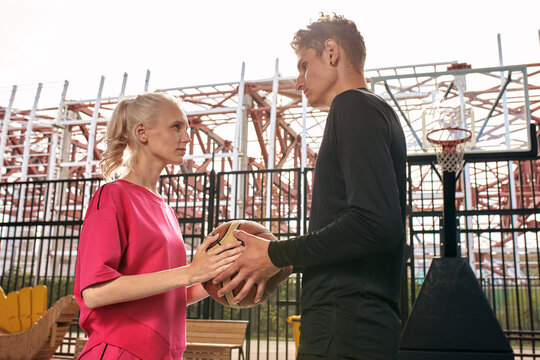 Diversity guy and girl playing basketball on the city playground